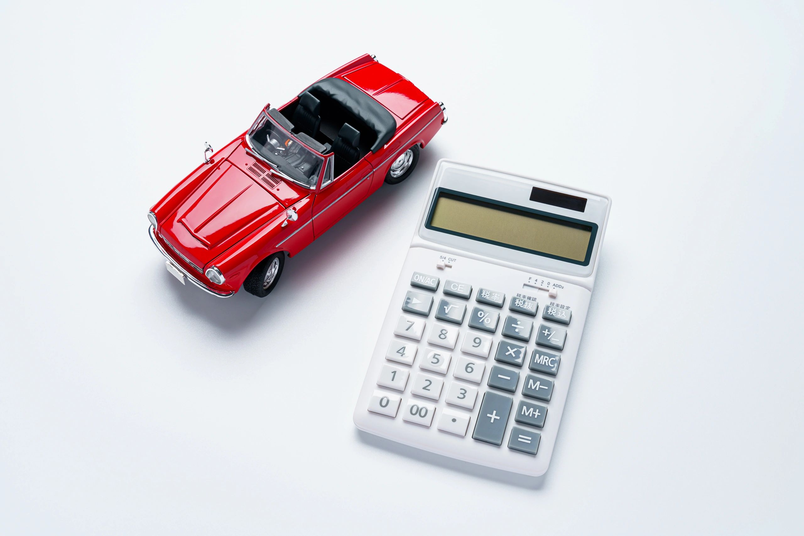 Calculator next to a car representing auto repair budgeting