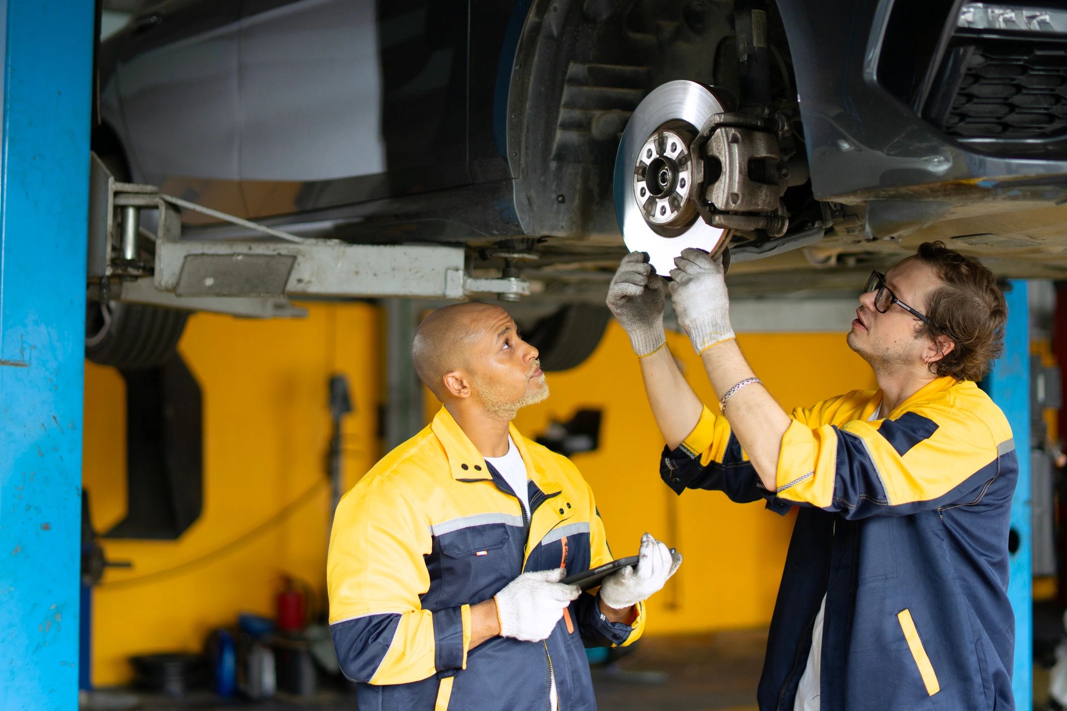 Car owner speaking with a mechanic in a service workshop