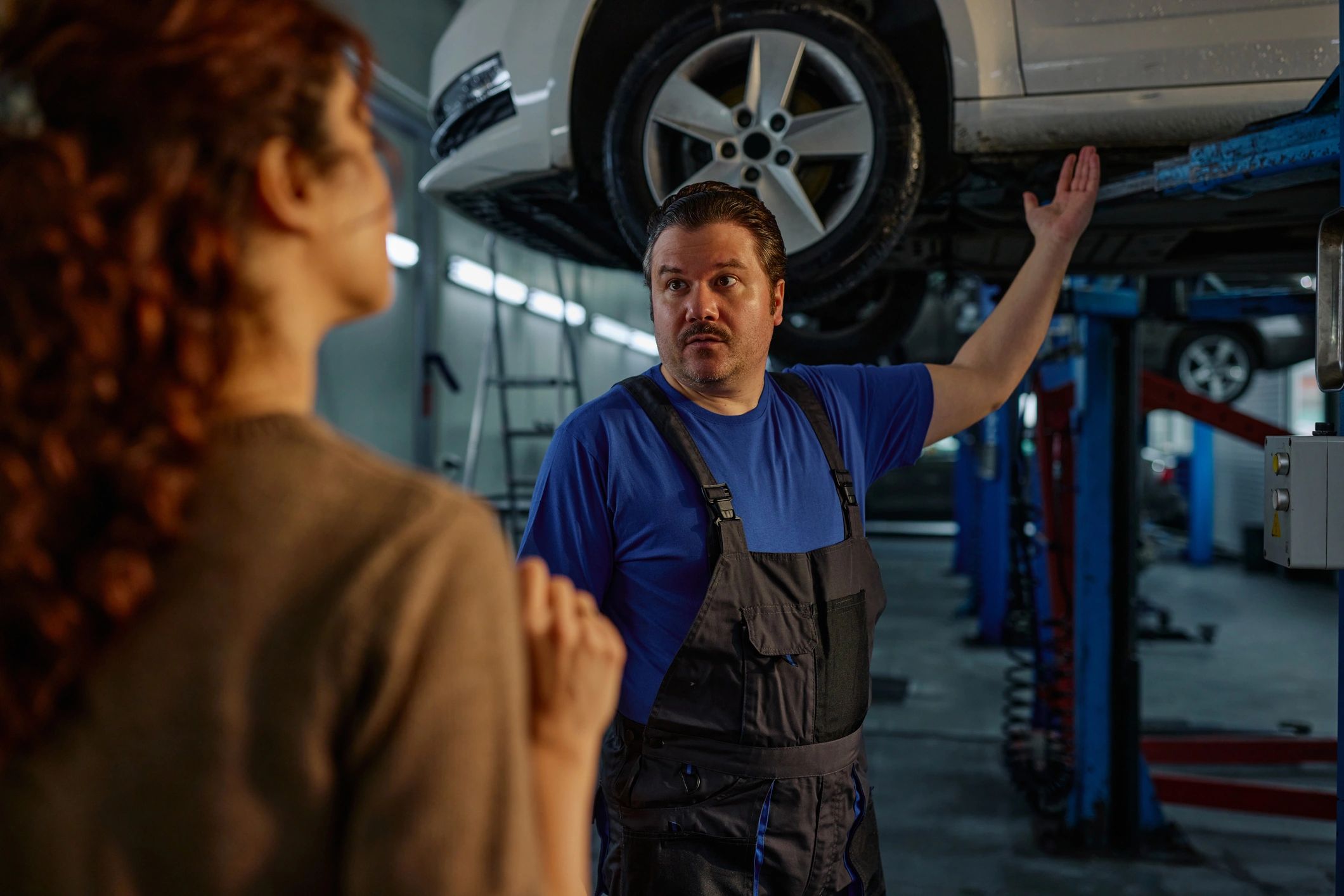 Mechanic explaining a vehicle issue to a customer